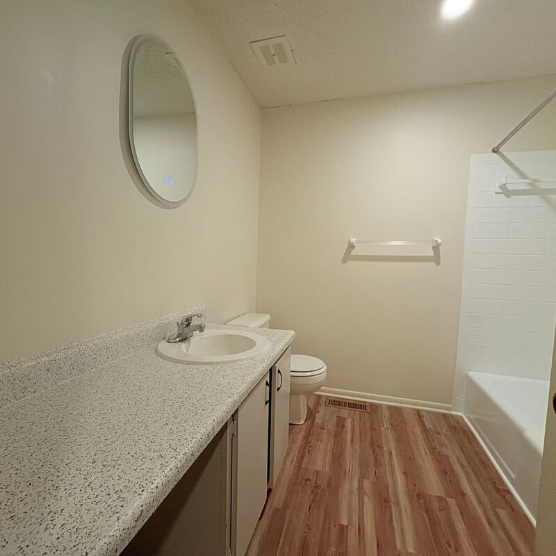 Updated bathroom with new vanity and round mirror
