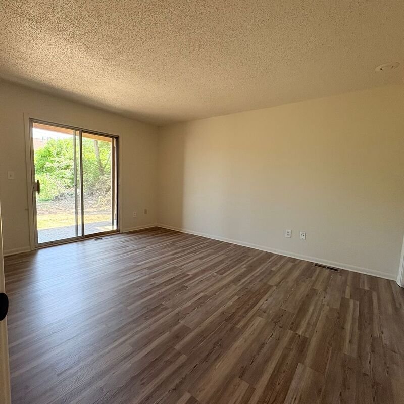 Bright living room with patio access and new flooring